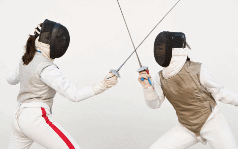 Women fencing in a competitive match with focused expressions and swift movements